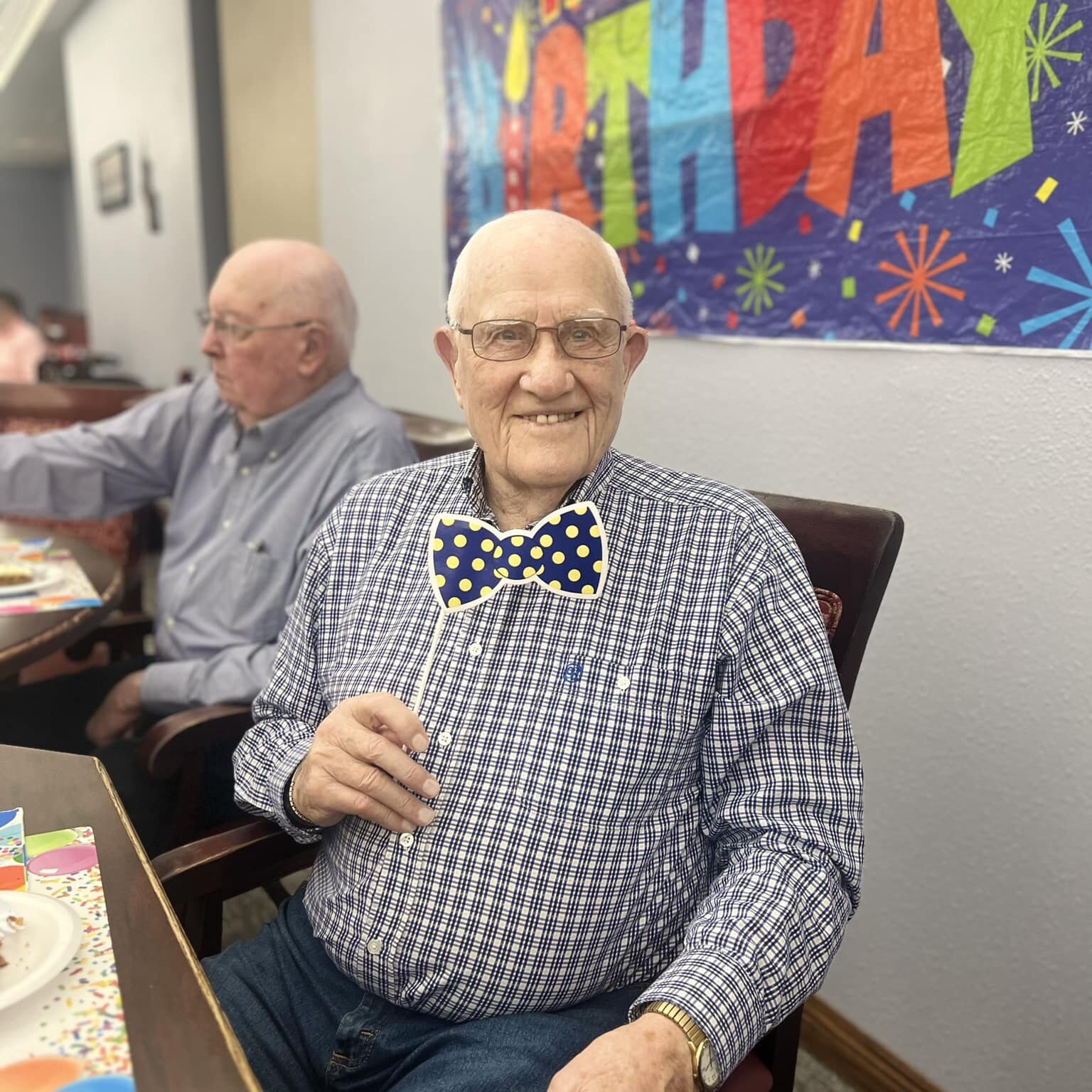 Elderly resident posing with bow tie prop