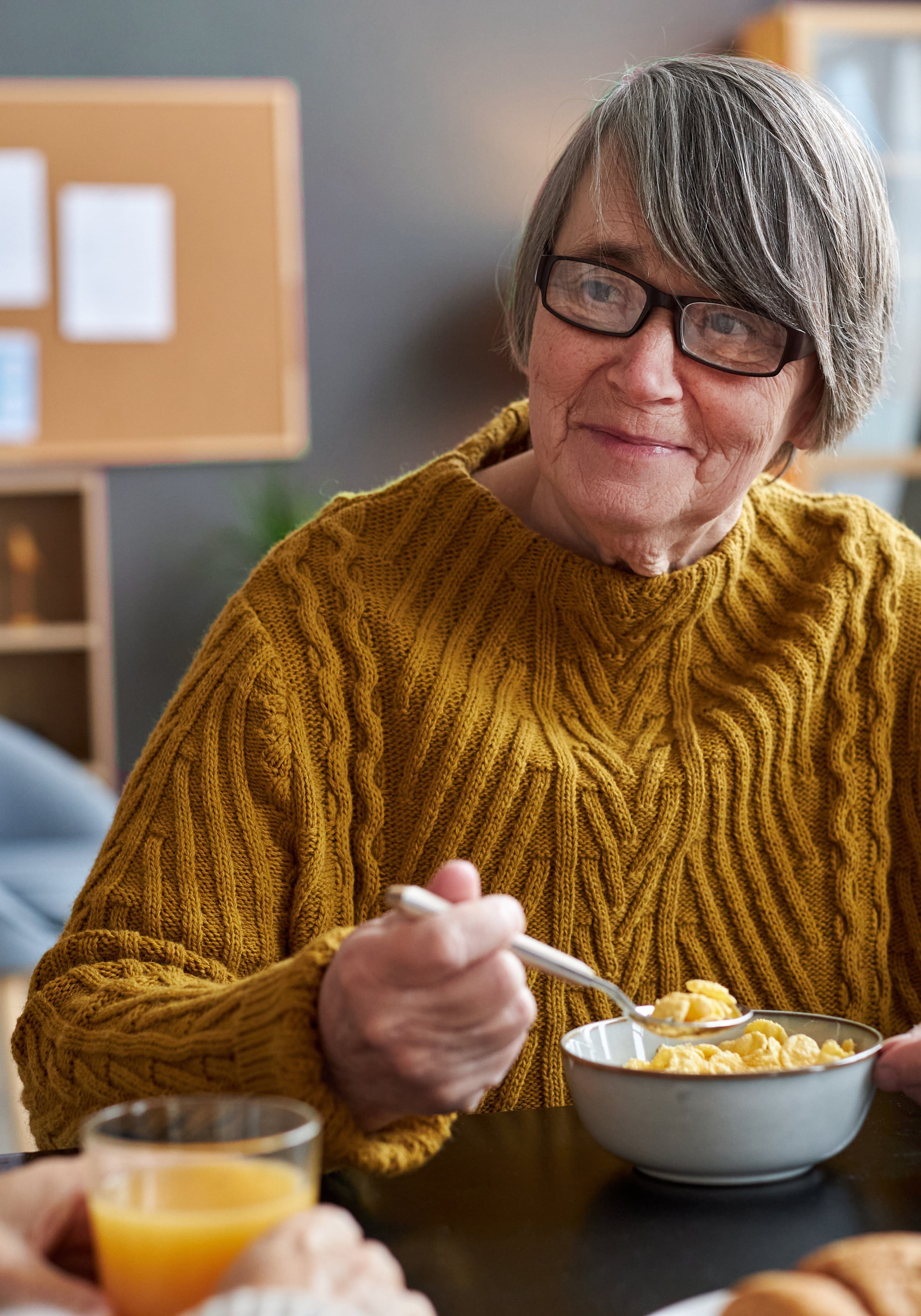 Smiling senior woman eating cereal